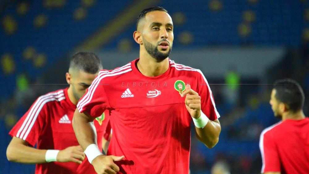 بنعطية يُقدِّم هدية لأحد الأطفال بعد لقاء الكاميرون