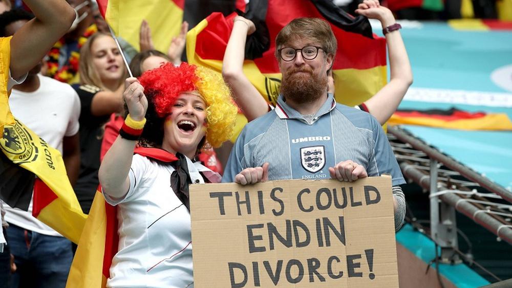 في "لقطة طريفة".. مشجع إنجليزي وزوجته الألمانية يرفعان لافتة كتب عليها "هذا اللقاء قد ينتهي بالطلاق"