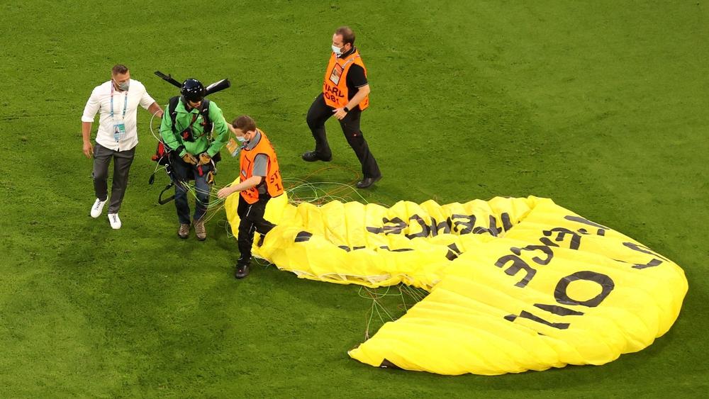 في "لقطة طريفة".. مظلي يحط مُحلِّقاً بأرضية ملعب "أليانز أرينا" قبل بداية مباراة ألمانيا وفرنسا بثوان